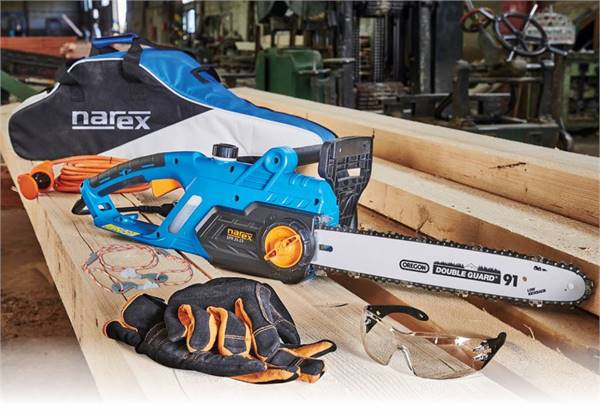 Male carpenter sawing a board with a circular saw in a carpentry workshop close-up